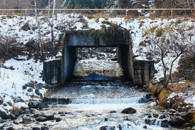 Yolun altından akan bir dağ nehri.