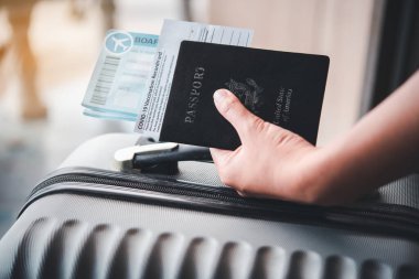 Pasaportları ve Coronavirus aşı kayıtlarını tutan insanlar yolculuk için bavullarıyla seyahat için harita tutuyorlar. Dünya çapında Covid-19