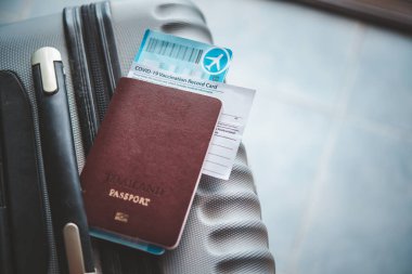 Seyahate hazırlanmak için pasaportlar ve bavullar ve Coronavirus aşı kayıt kartı, yolculuk için valizlerle seyahat haritası. Dünya çapında Covid-19