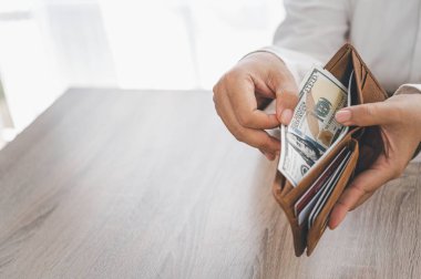 Adamın eli cebinden harcamak için bir dolar çıkarır..