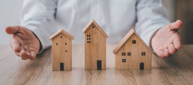 Emlakçı bir evi gösteriyor. Yeni bir ev almanın yanı sıra yeni bir ev alma fikri