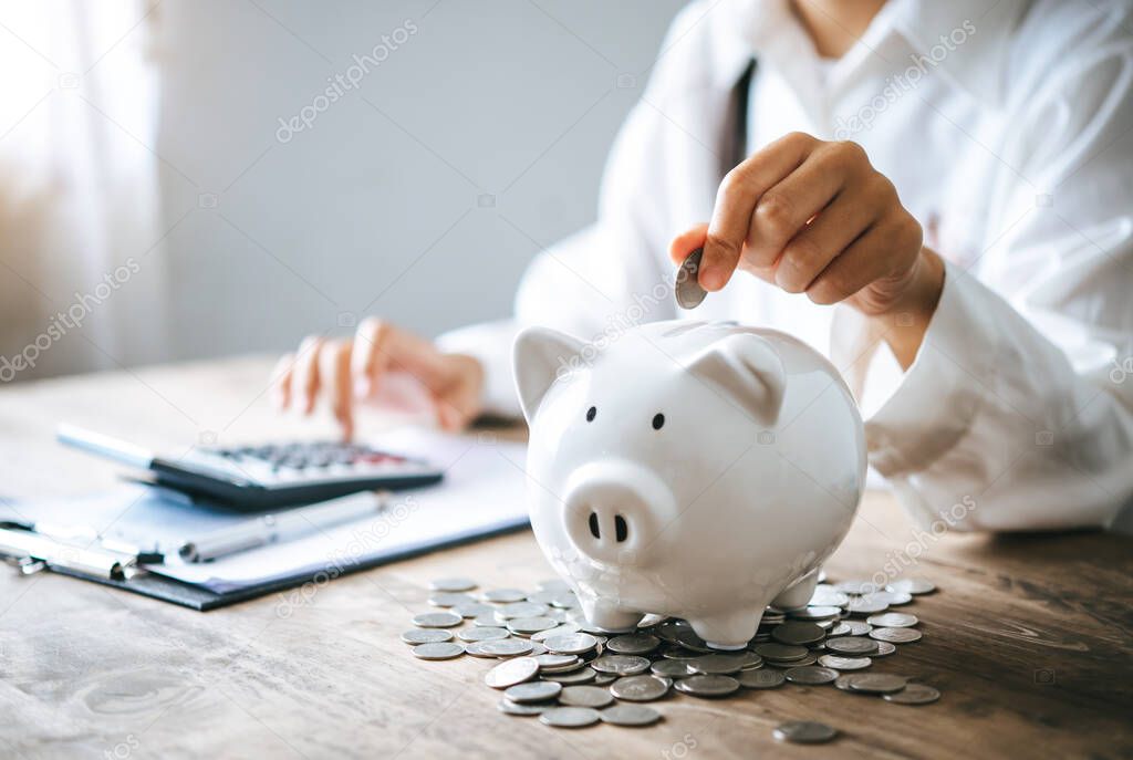   Hand holding coin with pig piggy bank. Saving and financial accounts concept