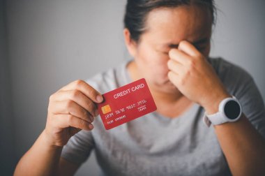 stressed woman with credit card due to inability to pay debts due to using the entire amount of money, being in debt, and having a high cost of living