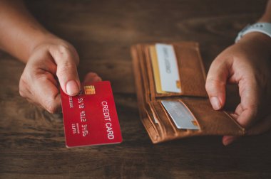 Kredi kartını tutan elleri kapat, dizüstü bilgisayarın klavyesine yaz, online alışveriş yap.