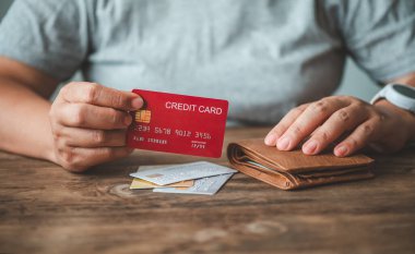 Kredi kartını tutan elleri kapat, dizüstü bilgisayarın klavyesine yaz, online alışveriş yap.