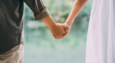 close-up of a young couple holding hands in nature