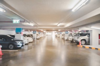 Abstract blur image of Many cars in parking garage interior at department store or shopping mall , industrial building for banner advertising background