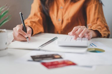 İş adamı, çalışmak için hesap makinesini kullanarak ofiste masa başında oturuyor. İş Konsepti Analizi ve Planlaması