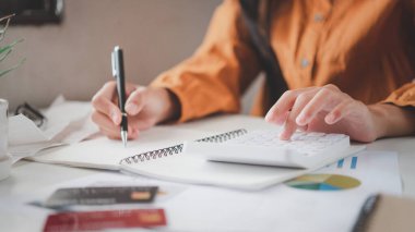 İş adamı, çalışmak için hesap makinesini kullanarak ofiste masa başında oturuyor. İş Konsepti Analizi ve Planlaması