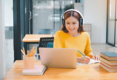  young student wearing headphones studies online, distance learning, and keeps up to date on the global coronavirus pandemic.