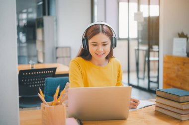  young student wearing headphones studies online, distance learning, and keeps up to date on the global coronavirus pandemic.