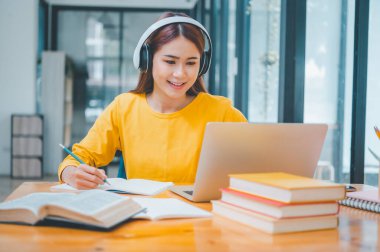  young student wearing headphones studies online, distance learning, and keeps up to date on the global coronavirus pandemic.