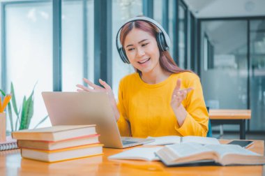 young student wearing headphones studies online, distance learning, and keeps up to date on the global coronavirus pandemic.