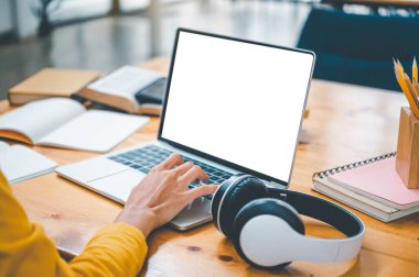 young student wearing headphones studies online, distance learning, and keeps up to date on the global coronavirus pandemic.