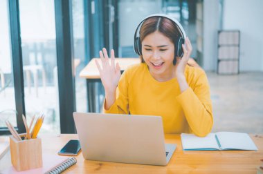 young student wearing headphones studies online, distance learning, and keeps up to date on the global coronavirus pandemic.