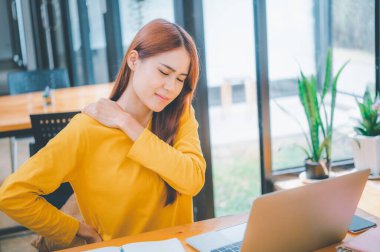 Female students studying online feel aches and pains while sitting online for long periods of time.