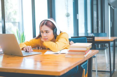 Female students are bored and sleepy during online classes while sitting online for long hours.