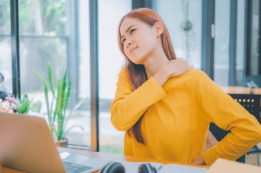 Female students studying online feel aches and pains while sitting online for long periods of time.