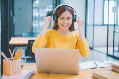 Female students are delighted to see results of their exams and get good grades while studying online.