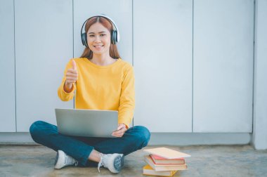 young student wearing headphones studies online, distance learning, and keeps up to date on the global coronavirus pandemic.
