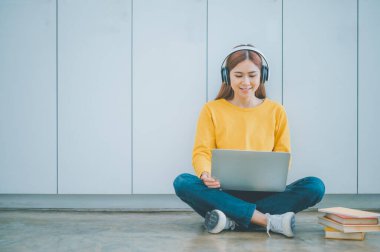 young student wearing headphones studies online, distance learning, and keeps up to date on the global coronavirus pandemic.