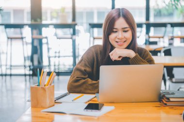 young student wearing headphones studies online, distance learning, and keeps up to date on the global coronavirus pandemic.