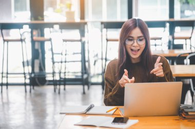 young student wearing headphones studies online, distance learning, and keeps up to date on the global coronavirus pandemic.
