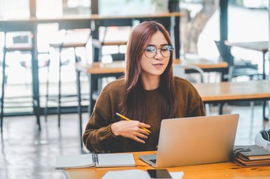 young student wearing headphones studies online, distance learning, and keeps up to date on the global coronavirus pandemic.