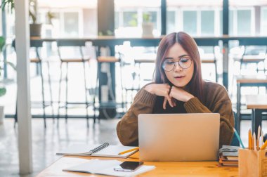 young student wearing headphones studies online, distance learning, and keeps up to date on the global coronavirus pandemic.