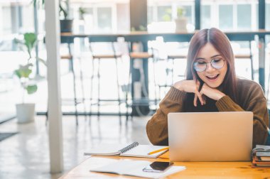 young student wearing headphones studies online, distance learning, and keeps up to date on the global coronavirus pandemic.