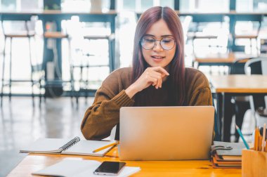 young student wearing headphones studies online, distance learning, and keeps up to date on the global coronavirus pandemic.