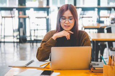 young student wearing headphones studies online, distance learning, and keeps up to date on the global coronavirus pandemic.
