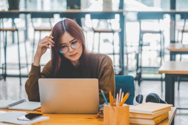 young student wearing headphones studies online, distance learning, and keeps up to date on the global coronavirus pandemic.