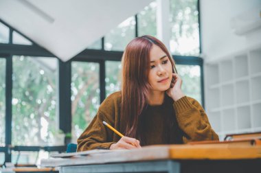 young student wearing headphones studies online, distance learning, and keeps up to date on the global coronavirus pandemic.