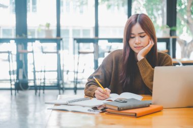 young student wearing headphones studies online, distance learning, and keeps up to date on the global coronavirus pandemic.