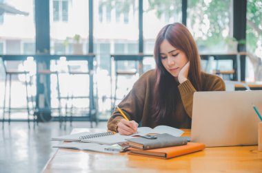 young student wearing headphones studies online, distance learning, and keeps up to date on the global coronavirus pandemic.