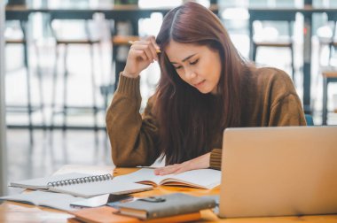 young student wearing headphones studies online, distance learning, and keeps up to date on the global coronavirus pandemic.