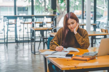 young student wearing headphones studies online, distance learning, and keeps up to date on the global coronavirus pandemic.