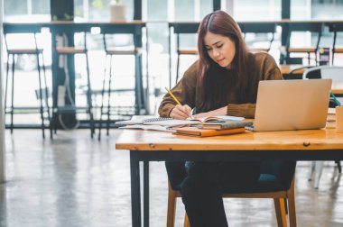 young student wearing headphones studies online, distance learning, and keeps up to date on the global coronavirus pandemic.