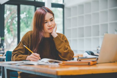 young student wearing headphones studies online, distance learning, and keeps up to date on the global coronavirus pandemic.