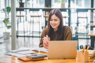 young student wearing headphones studies online, distance learning, and keeps up to date on the global coronavirus pandemic.
