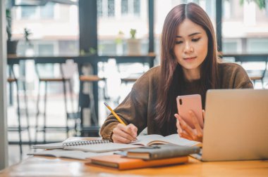 young student wearing headphones studies online, distance learning, and keeps up to date on the global coronavirus pandemic.