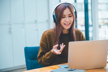 young student wearing headphones studies online, distance learning, and keeps up to date on the global coronavirus pandemic.