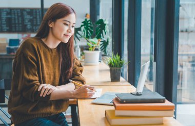young student wearing headphones studies online, distance learning, and keeps up to date on the global coronavirus pandemic.	