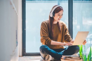 young student wearing headphones studies online, distance learning, and keeps up to date on the global coronavirus pandemic.	