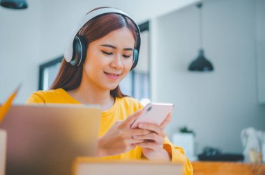 young student wearing headphones studies online, distance learning, and keeps up to date on the global coronavirus pandemic.