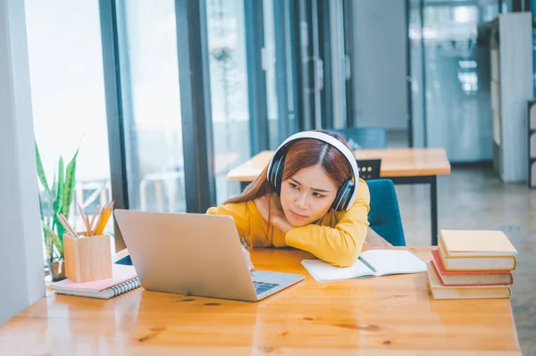 Female students are bored and sleepy during online classes while sitting online for long hours.