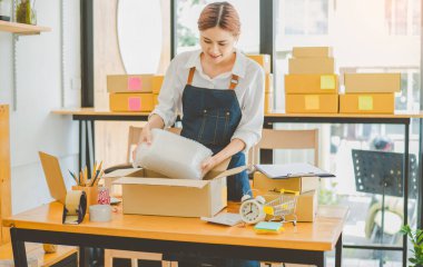 Online small business owners are packing their ordered products into the boxes for their customers based on the concept of online shopping - online shopping.