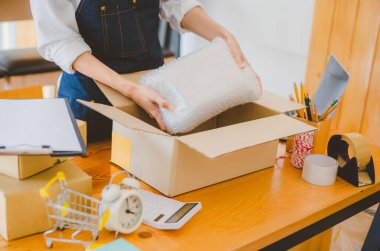 Online small business owners are packing their ordered products into the boxes for their customers based on the concept of online shopping - online shopping.