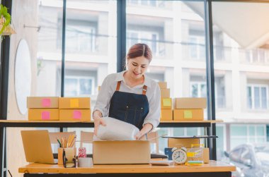 Online small business owners are packing their ordered products into the boxes for their customers based on the concept of online shopping - online shopping.
